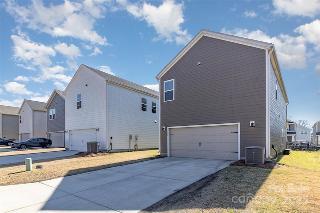 view of home's exterior featuring concrete driveway, central AC unit, and an attached garage