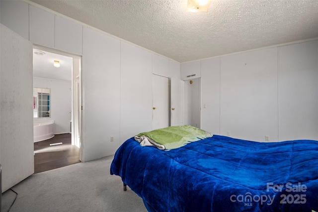 carpeted bedroom featuring a textured ceiling, visible vents, and a decorative wall