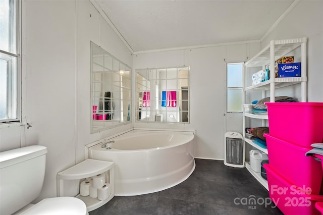 bathroom featuring toilet and a garden tub