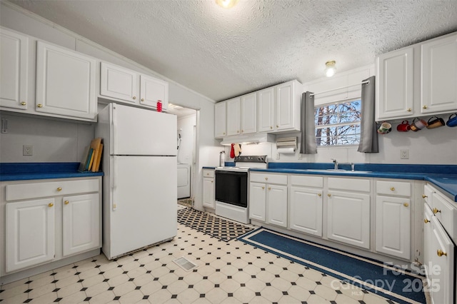 kitchen with white appliances, under cabinet range hood, white cabinets, and light floors