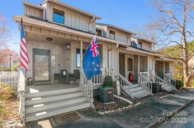 multi unit property featuring board and batten siding, covered porch, fence, and central air condition unit