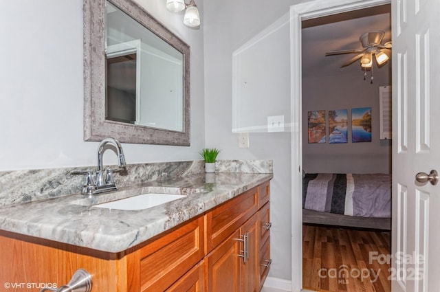 bathroom featuring ceiling fan, wood finished floors, connected bathroom, and vanity