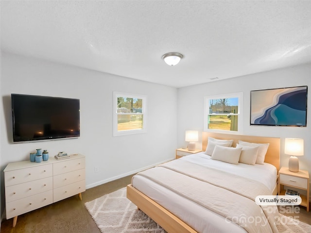 bedroom featuring multiple windows, baseboards, and dark colored carpet