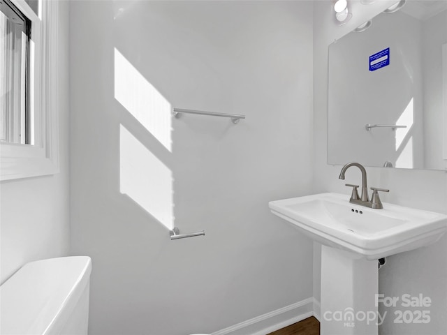 bathroom featuring toilet and baseboards