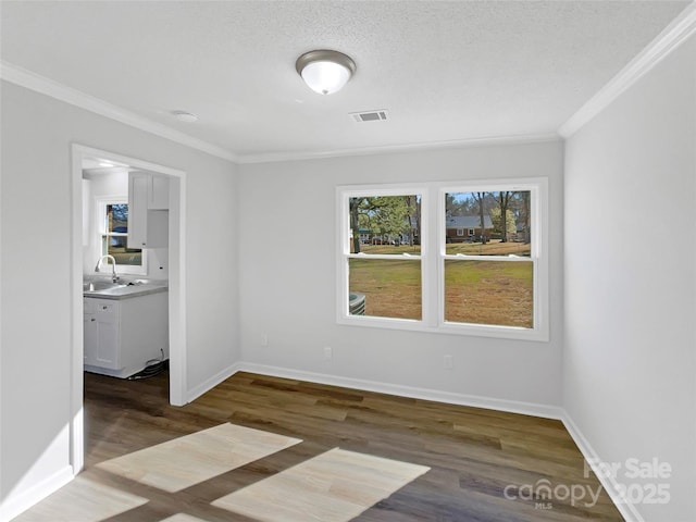 spare room with baseboards, visible vents, dark wood-type flooring, and ornamental molding