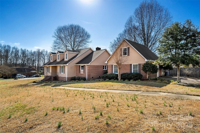 view of front of property featuring brick siding, crawl space, a front yard, and fence