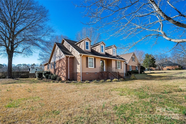 view of home's exterior featuring brick siding, a yard, and fence