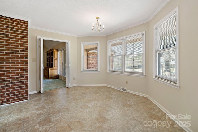 spare room featuring a chandelier, visible vents, crown molding, and baseboards