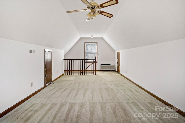 bonus room featuring lofted ceiling, light colored carpet, visible vents, baseboards, and heating unit