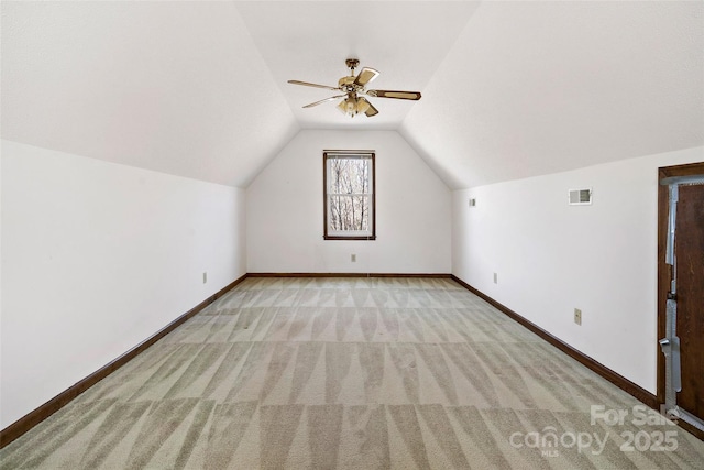 additional living space with carpet floors, visible vents, vaulted ceiling, and baseboards