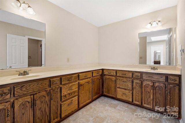 bathroom featuring a skylight, a sink, and double vanity