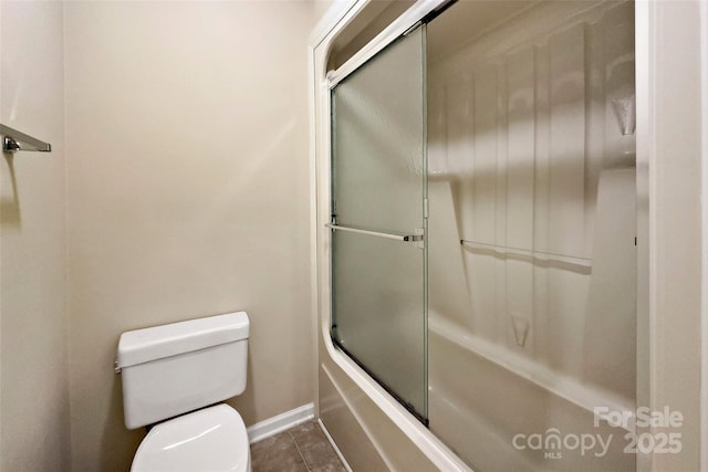 full bath featuring toilet, shower / bath combination with glass door, tile patterned flooring, and baseboards