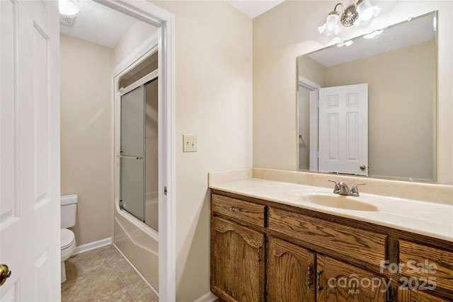 full bath with toilet, combined bath / shower with glass door, vanity, tile patterned flooring, and baseboards