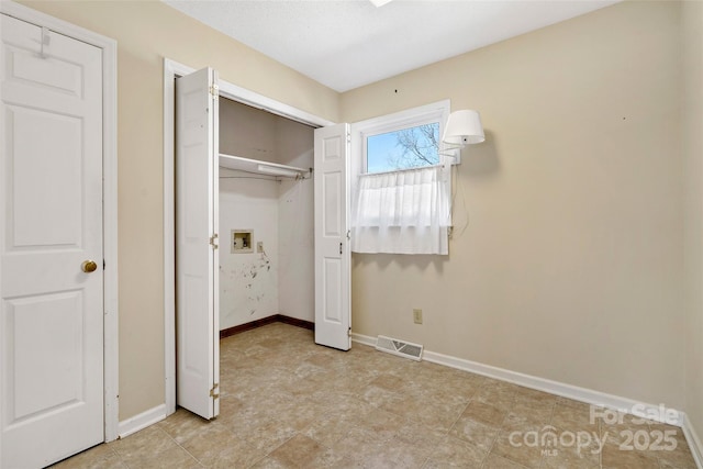 unfurnished bedroom with a closet, visible vents, and baseboards