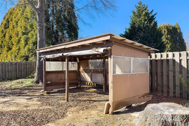 view of outbuilding featuring an outdoor structure and fence