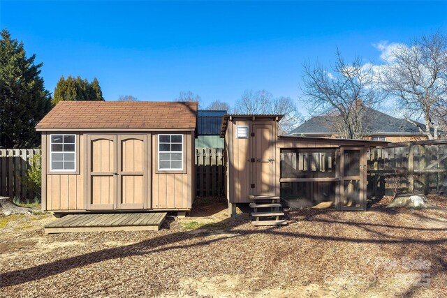 view of shed with fence and exterior structure