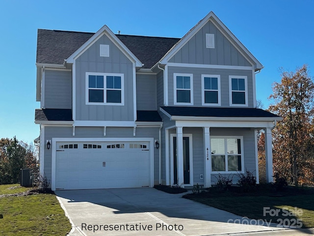 view of front of home featuring driveway, a shingled roof, an attached garage, cooling unit, and board and batten siding