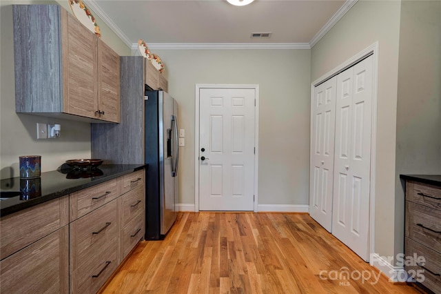 kitchen with ornamental molding, visible vents, light wood-style floors, and stainless steel fridge with ice dispenser