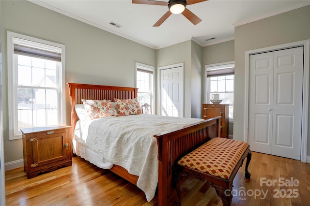 bedroom with visible vents, multiple windows, and two closets