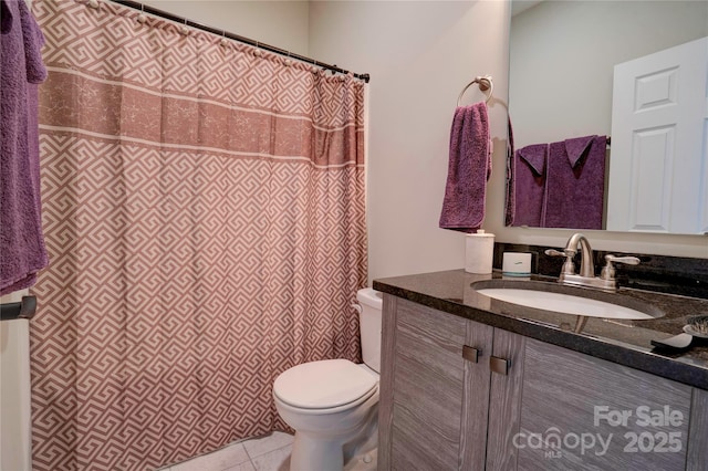 bathroom with a shower with curtain, vanity, toilet, and tile patterned floors