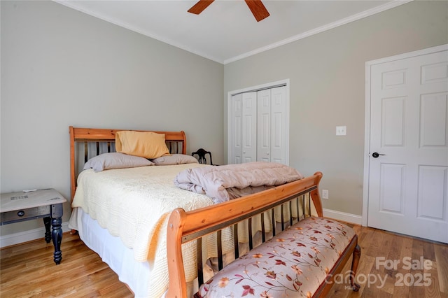 bedroom featuring ceiling fan, baseboards, light wood-style floors, a closet, and crown molding