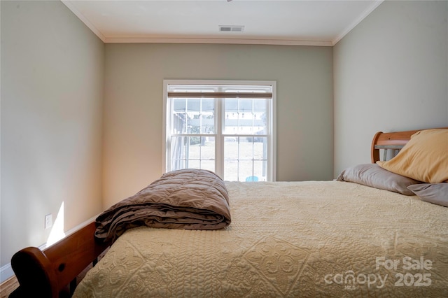 bedroom with baseboards, visible vents, and ornamental molding