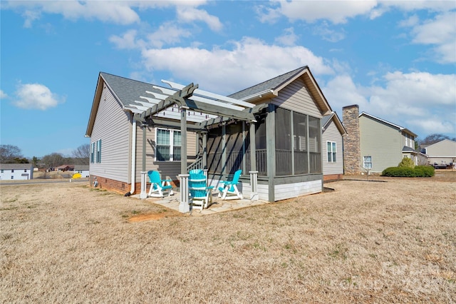 back of house with crawl space, a sunroom, a lawn, and a pergola