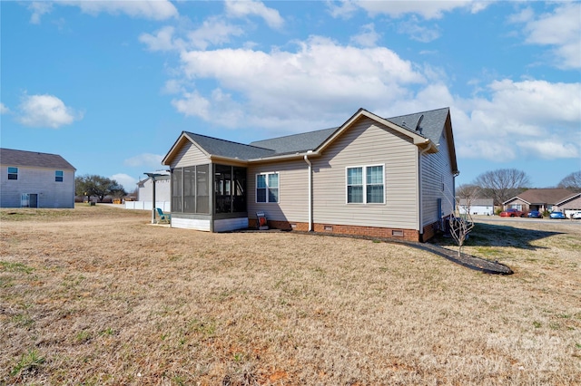 rear view of property featuring a sunroom, a yard, and crawl space