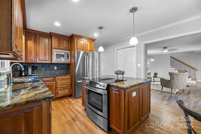 kitchen with stainless steel appliances, light wood-type flooring, a sink, and brown cabinets