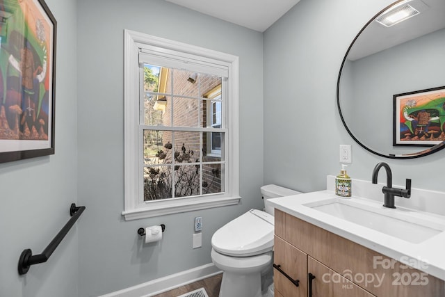 bathroom featuring visible vents, vanity, toilet, and baseboards