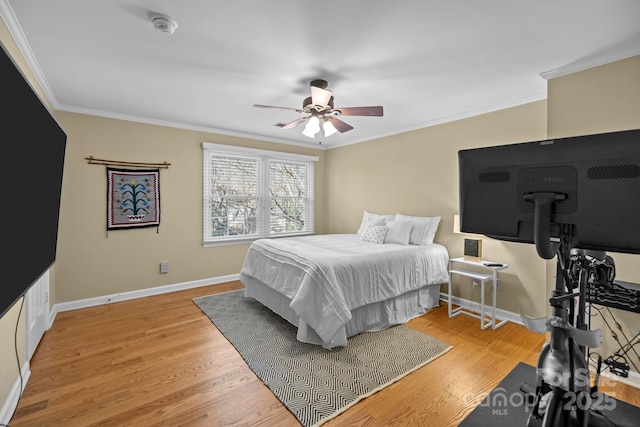 bedroom with ornamental molding, light wood-type flooring, and baseboards