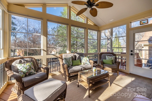 sunroom / solarium with lofted ceiling, a ceiling fan, and a wealth of natural light