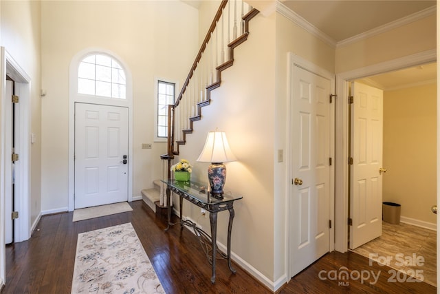 foyer featuring crown molding, stairs, baseboards, and wood finished floors