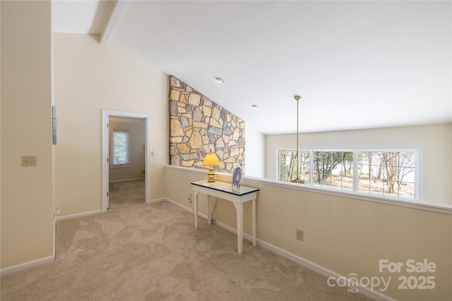 hallway featuring carpet floors, lofted ceiling with beams, and baseboards