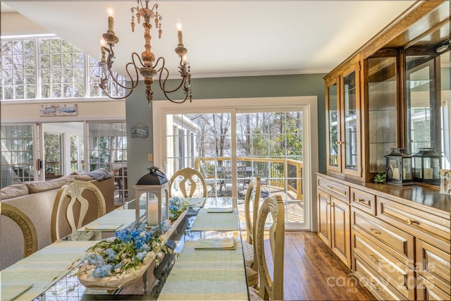 dining space featuring dark wood-style floors, a chandelier, and crown molding