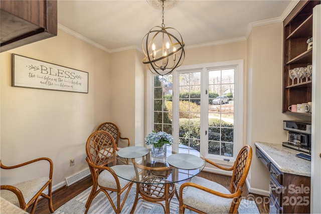 dining room with crown molding, dark wood-style flooring, a notable chandelier, and baseboards