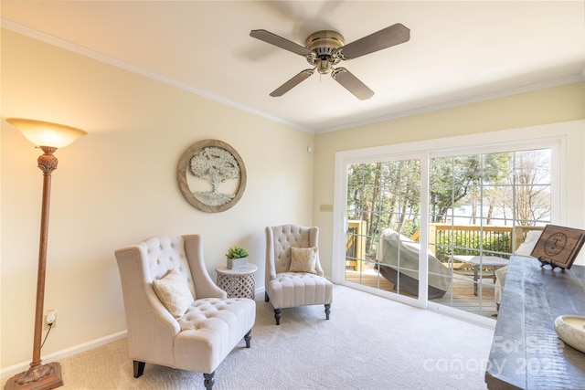 living area with a ceiling fan, carpet, baseboards, and crown molding