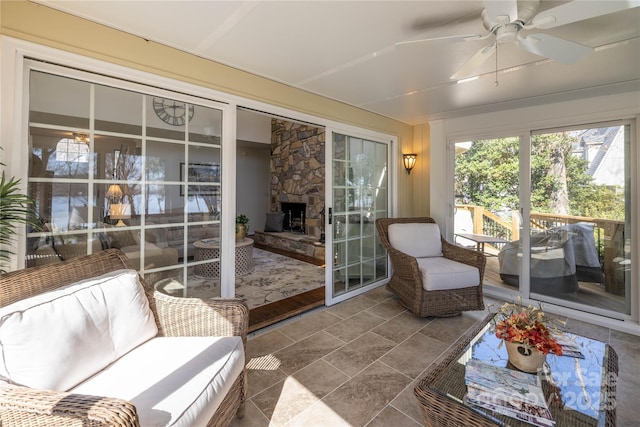 sunroom with a fireplace and a ceiling fan