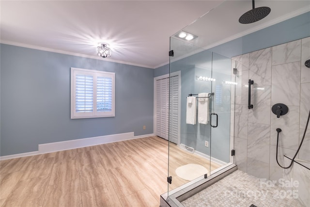 full bath with ornamental molding, a shower stall, and baseboards