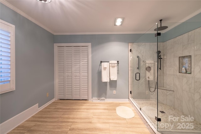 bathroom with a stall shower, baseboards, and ornamental molding