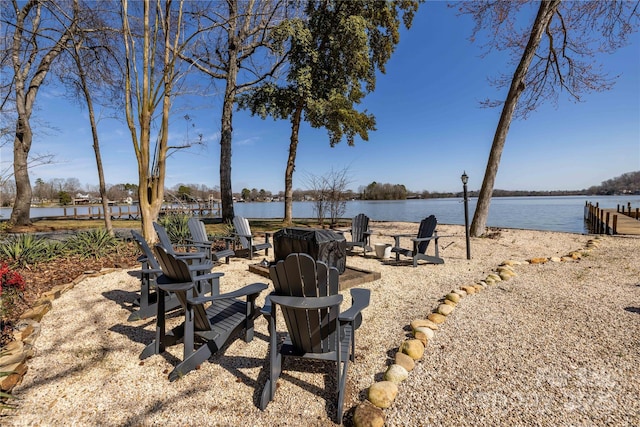 view of yard featuring a fire pit, a patio area, and a water view