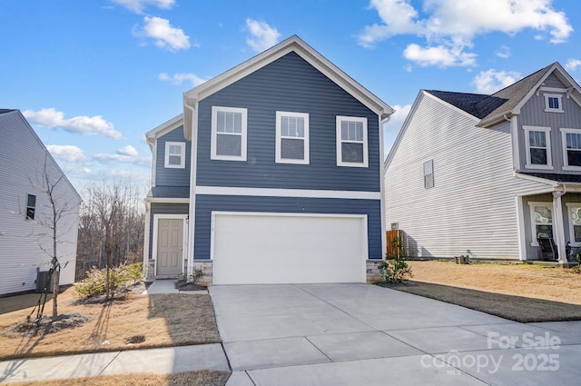 traditional home featuring stone siding, driveway, and an attached garage