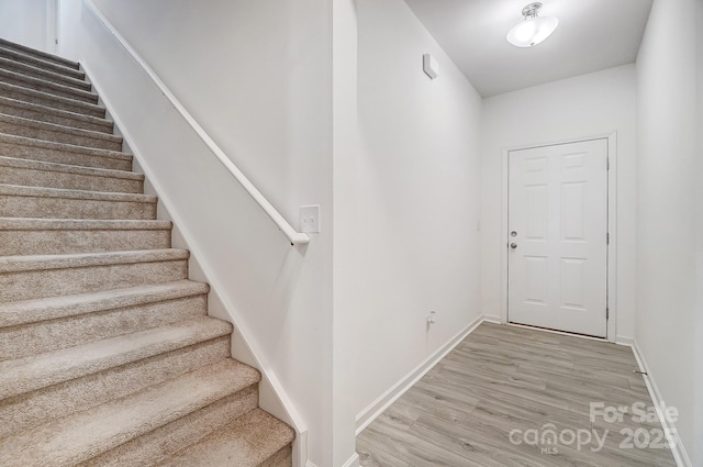 stairway with baseboards and wood finished floors