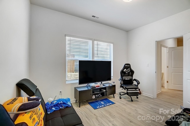 living area featuring wood finished floors, visible vents, and baseboards