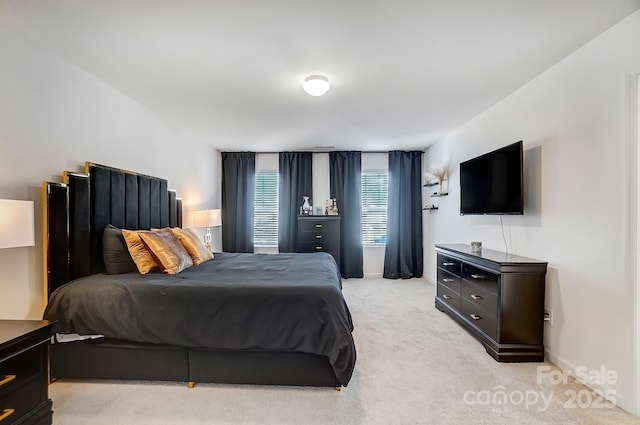 bedroom with baseboards and light colored carpet