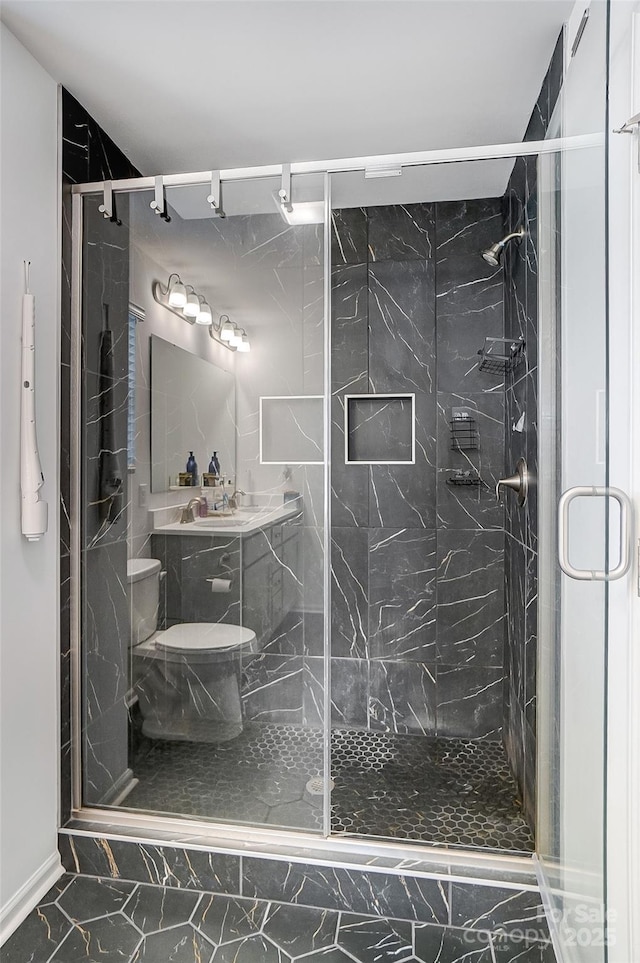 bathroom with a marble finish shower, marble finish floor, and toilet