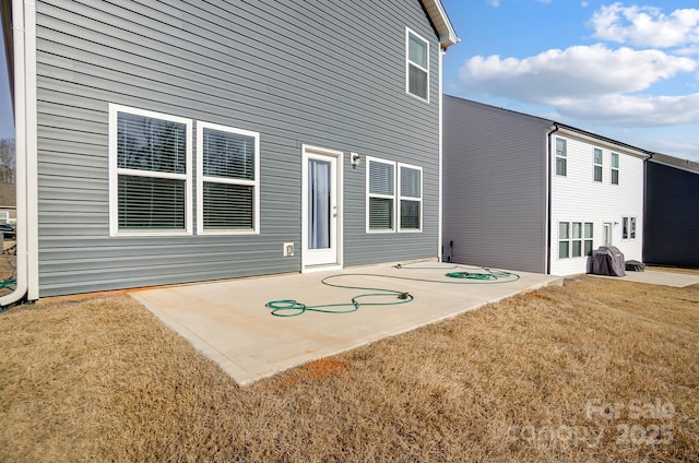 back of property with a lawn and a patio area