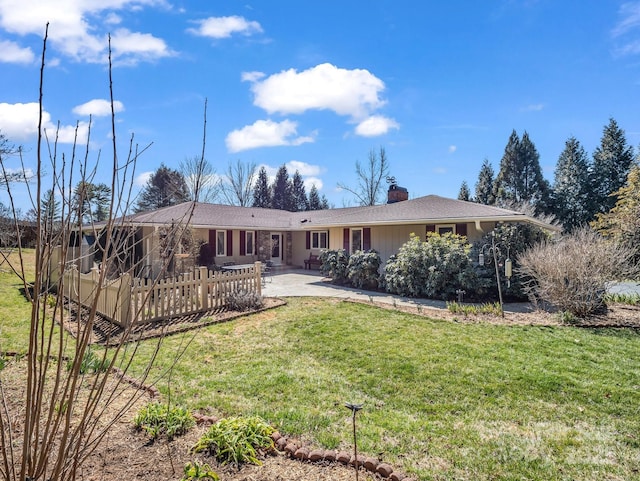 rear view of property featuring a yard, a chimney, and a patio area