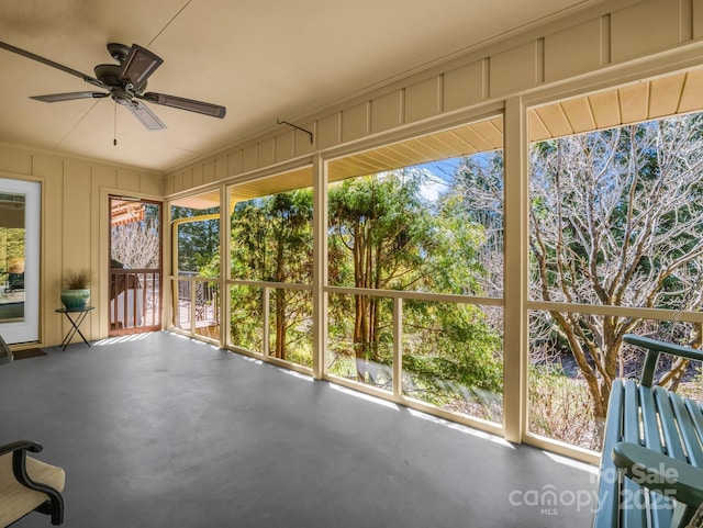 unfurnished sunroom featuring ceiling fan