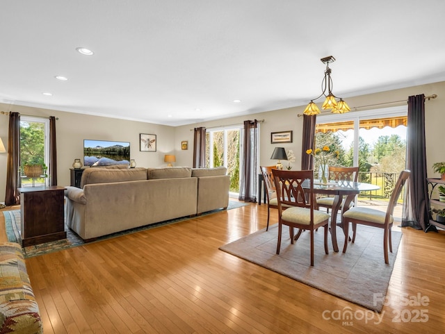 dining area featuring light wood-type flooring, crown molding, and recessed lighting